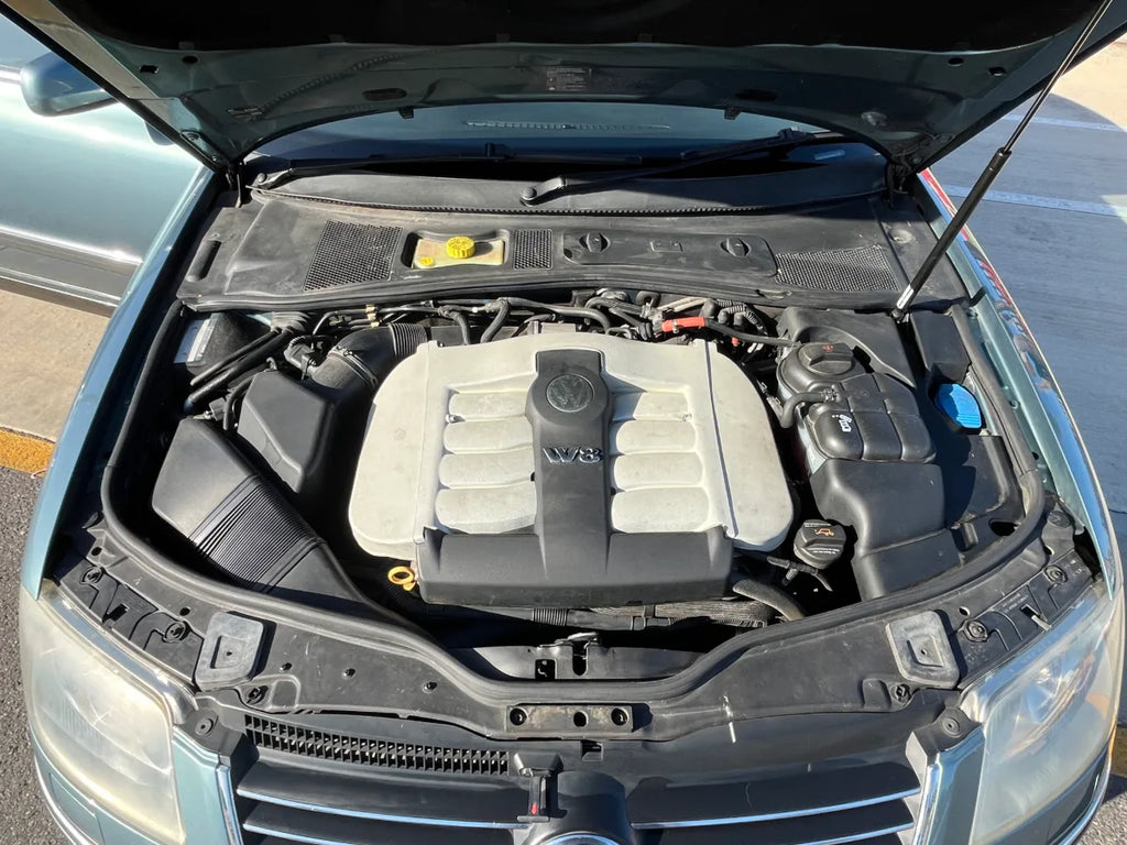 Car engine compartment with open hood on a road