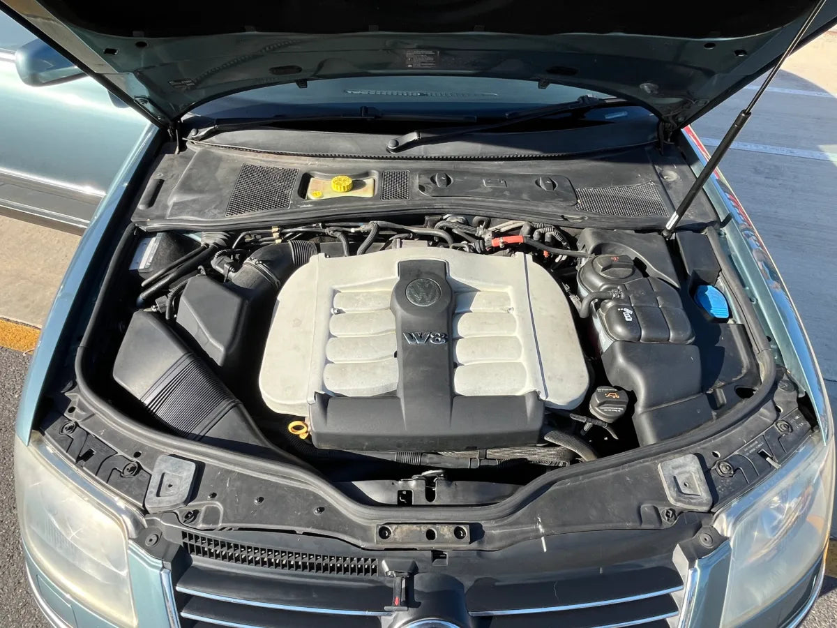 Car engine compartment with open hood on a road