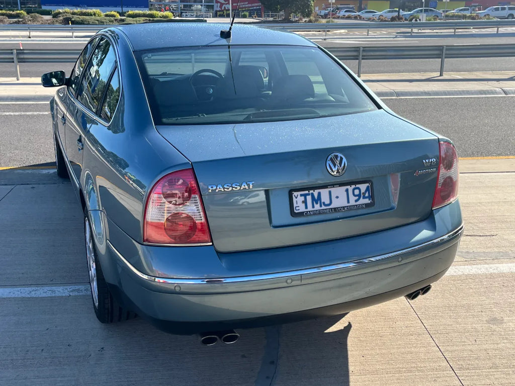 Blue Volkswagen Passat on a road with a clear sky