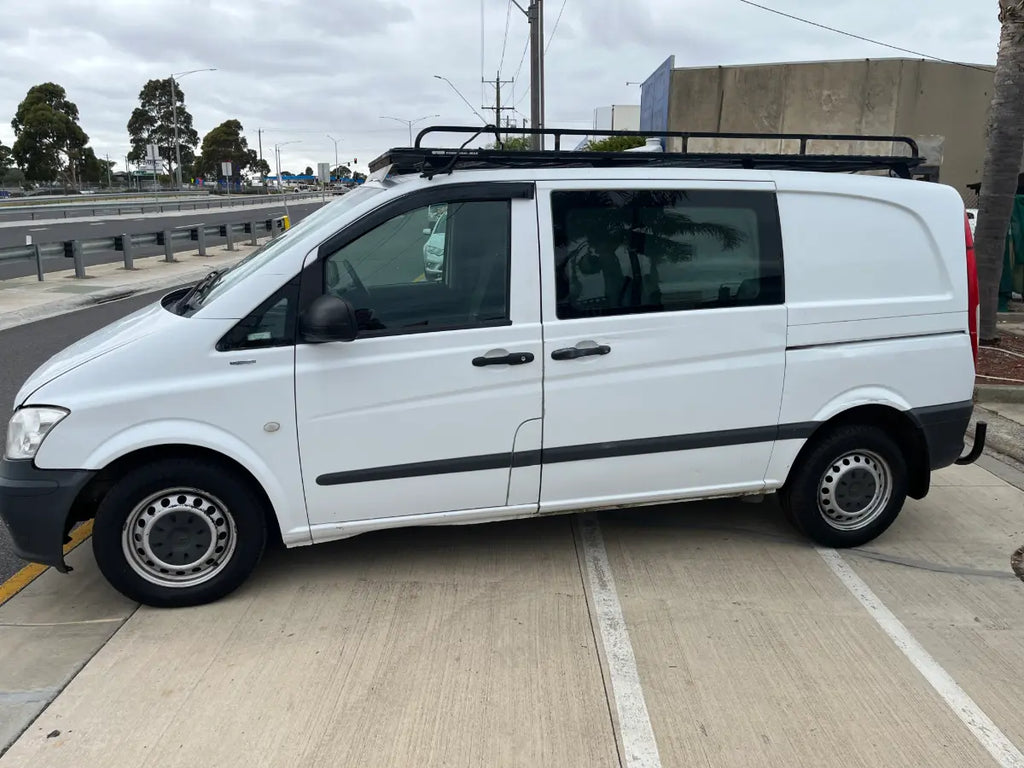 White van with a roof rack parked on a street