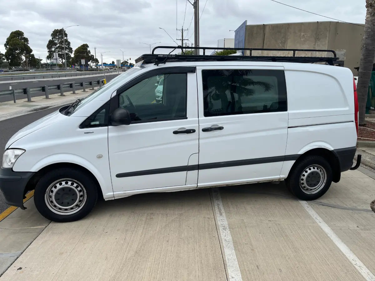 White van with a roof rack parked on a street