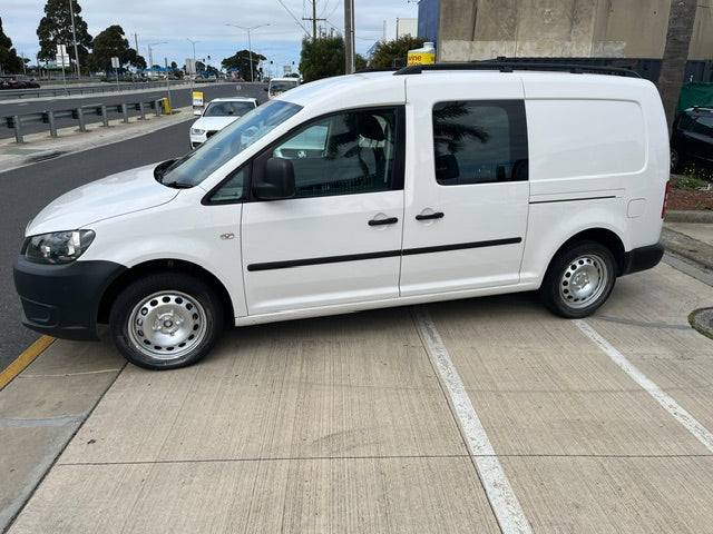 Side view of white Volkswagen Caddy Crew Cab with roof racks