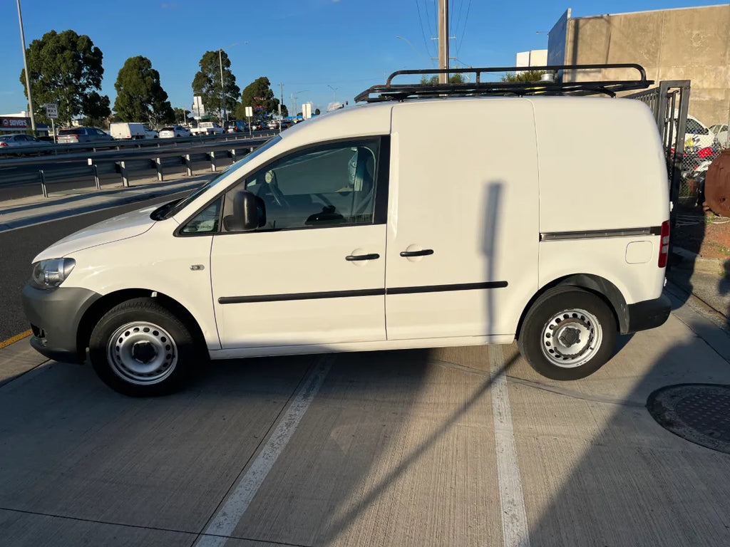 White van with a roof rack on a road