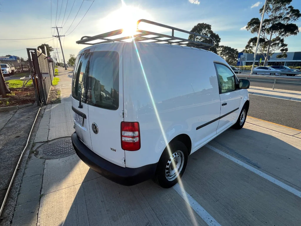 White van with a roof rack on a street