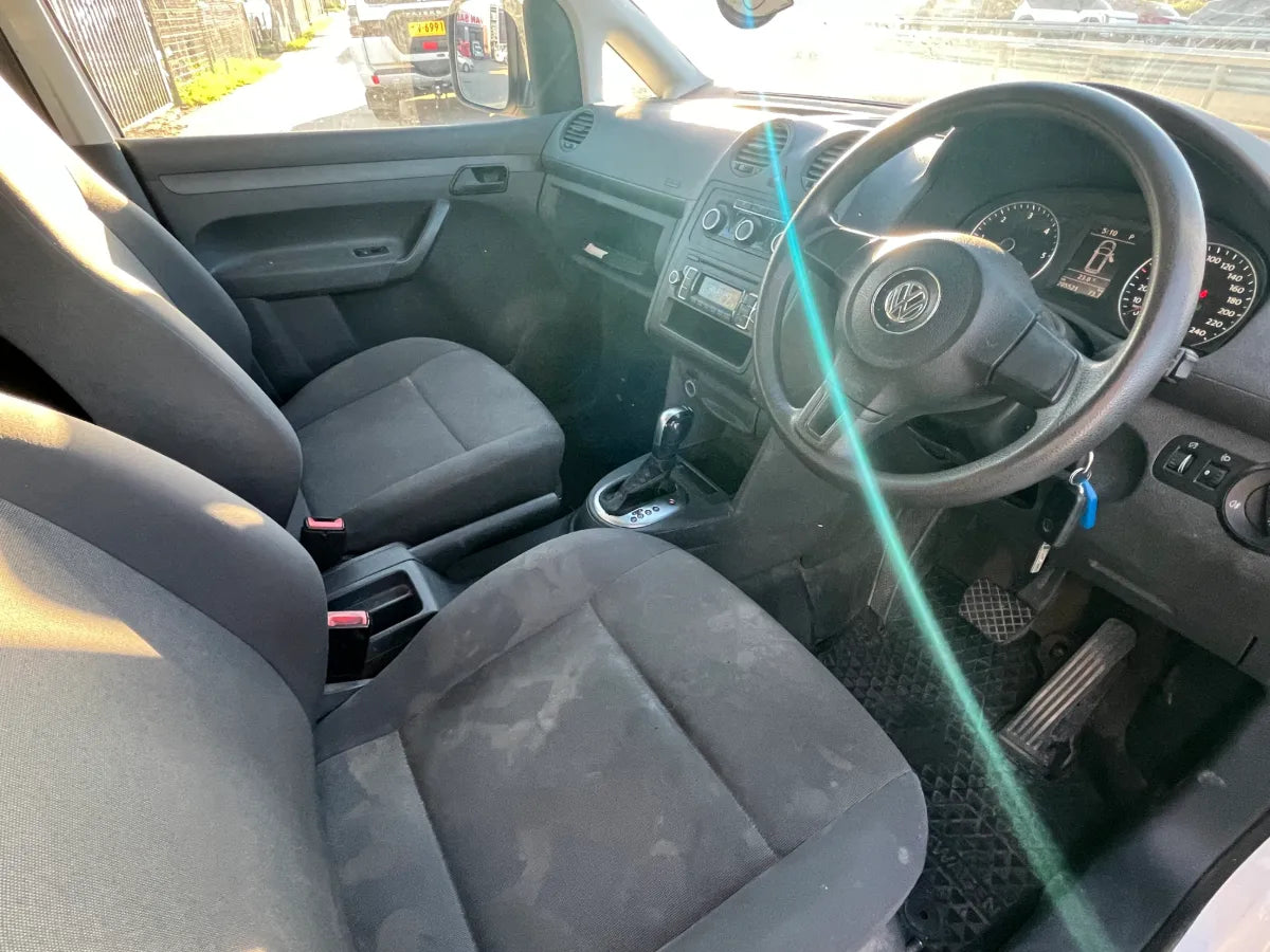 Car interior with steering wheel and dashboard, showing signs of wear.