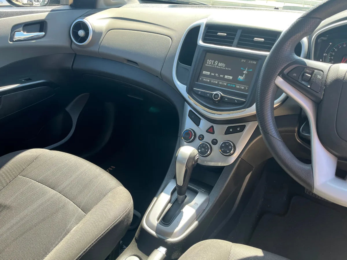 Car interior with steering wheel, dashboard, and center console.