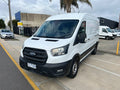 Front three-quarter view of white 2021 Ford Transit long wheelbase mid roof van
